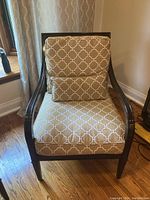 Front view of the chair showing the fabric cushion and wood frame with armrests.