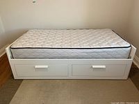 Front view of assembled white daybed frame with mattress