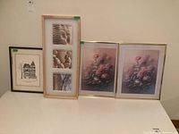 Four framed prints shown: two floral prints in gold frames, one triptych stone photograph in light wood frame, and one architectural drawing in black frame.