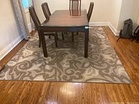 View of 8x10 machine made area rug under dining table on hardwood floor
