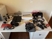 Overview of items on table including phones, scanner box, slide rules, headphones, and cables