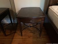 Front view of wooden side table showing slight wear and drawer detached.