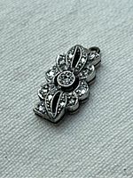 Front-facing close-up view showing openwork pattern and round-cut diamond settings.