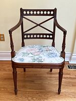 Front view showing carved circular motif back, X-cross splat, fluted legs, and upholstered seat