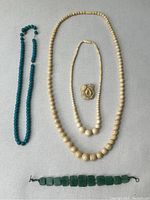 Overview of all five jewelry pieces on fabric background