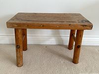 Front view showing entire bench with four round legs and solid top