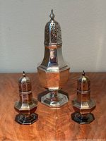 All three shakers displayed together on wood surface against neutral background