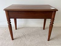 Front view of antique walnut side table showing rectangular top and tapered legs with turned detailing.