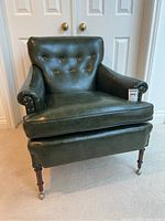 Front view showing tufted vinyl upholstery, rolled arms and removable seat cushion