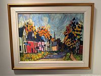 Frontal view of the oil on board painting in gold-tone frame with linen liner showing row of colorful houses and autumn trees.