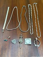 Overall layout showing all chains, bracelet, earrings, pins and brooches