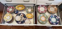 Wide view of two drawers filled with assorted plate stacks and serving pieces