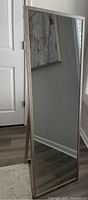 Front view of the full-length metal framed floor mirror, showing reflective surface and silver frame design.