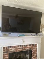 Samsung 55-inch TV mounted above a fireplace