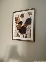 Framed floral artwork hung on a wall showing overall condition and design.
