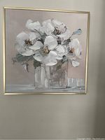 Photo of a square wall decor painting showing white flowers in a clear vase with a soft neutral background and gold trim frame.