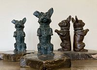Front view showing two Scottie dogs and two French Bulldogs posed upright on plaster bases.