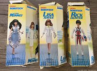 Three original boxed Robotech toy figures from Matchbox including Lynn Minmei, Lisa Hayes, and Rick Hunter standing side by side.