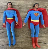Two Mego Superman 12 inch figures side by side, showing front view highlighting fabric suits and overall condition.