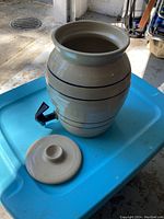 Carafe with spout and removed lid outside on a blue surface, showing the open top and smooth interior.