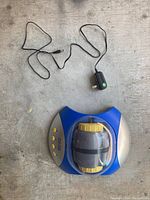 Top view of Explore One rock tumbler with attached power adapter laid out separately