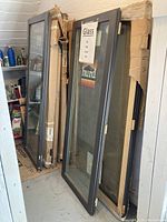 Three Hurd windows leaning against wall with cardboard packaging