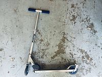 Full view of the Razor scooter showing metal frame, blue grips, and wheels on concrete floor.
