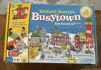 Photo of the front of the Richard Scarry's Busytown Eye Found It board game box showing colorful cartoon town illustration and kids playing on a long game board.