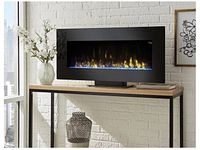 Electric fireplace displayed on a stand against a white brick wall with decorative items nearby.