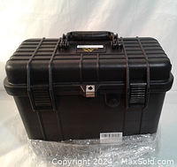 Closed black protective hard case with handle, lock latch, and side latches visible