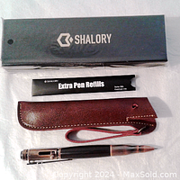 Box, extra pen refills packet, leather belt holder, and the bolt action pen with compass in front.