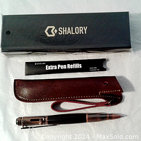 SHALORY branded box, extra pen refill packet, brown leather belt holder, and pen with compass