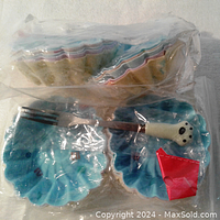 Two packs of blue silicone cupcake liners with scalloped edges featuring pastel colors, sealed in plastic bags.
