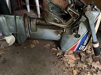 Side profile of lower unit and cowling showing Evinrude 15 decal and tiller handle