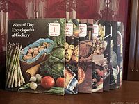 Photo of volumes 1 to 11 showing the colorful hardcovers with photographic food images and red volume number labels.