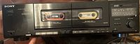 Front view of the Sony dual cassette player showing both cassette decks, control buttons, and cassette tapes inserted.