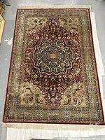 Full top-down view of rug laid flat showing overall medallion pattern, border and fringe