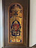 Full view of the arched stained glass window panel mounted in a wooden frame