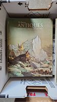 Top cover of a single issue of "The Magazine Antiques" dated February 1977 featuring an illustration of a ship among icebergs.