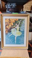 Woven painting of a ballet dancer in a yellow and white tutu in an ornate frame, showing full artwork and framing