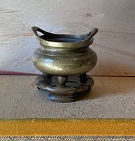 Front view of the Chinese bronze incense burner on its bronze stand, showing shape and size.