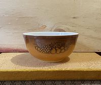 Side view of the large CorningWare Pyrex mixing bowl showing brown exterior with fruit pattern decor