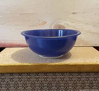 Side profile of the large blue CorningWare Pyrex bowl showing its smooth, glossy finish and flared rim.