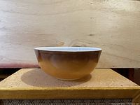 Side view of the CorningWare Pyrex mixing bowl showing the amber-yellow gradient color.