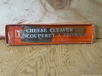 Orange box for cheese cleaver knife with white and black text and small logo.