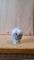 Small porcelain vase with Famille Rose decoration showing two Western figures in colorful traditional dress, on short neck and pierced openwork base.