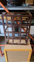 Front view of the wooden wine bottle holder showing the grid compartments for 12 bottles.
