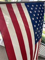 Close-up photo of American flag showing red and white stripes and blue field with stars.