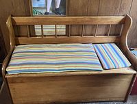 Photo of the vintage pine chest with striped cushions from front angle, showing the backrest and seat cushions.