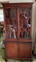 Front view of mahogany china cabinet with glass and wooden doors.